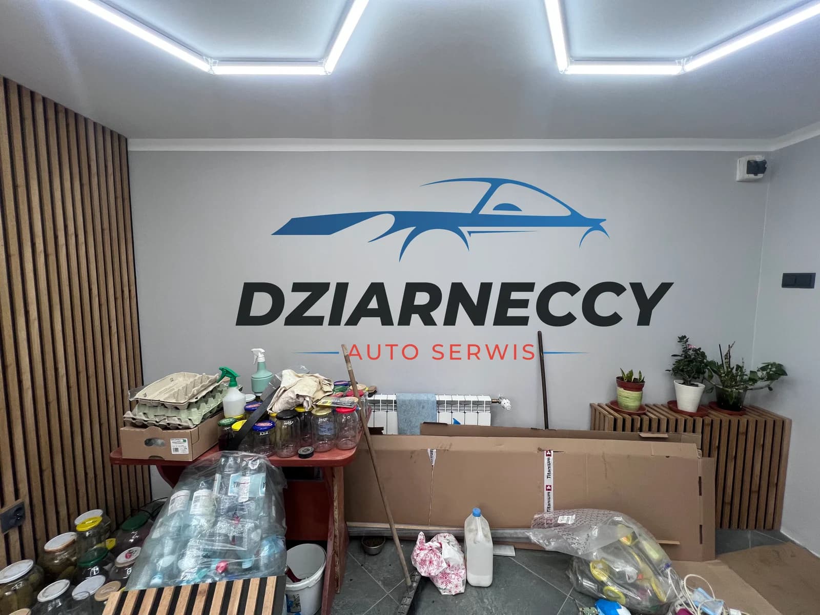 Niebiesko-czarne logo Dziarneccy Auto Serwis na ścianie
